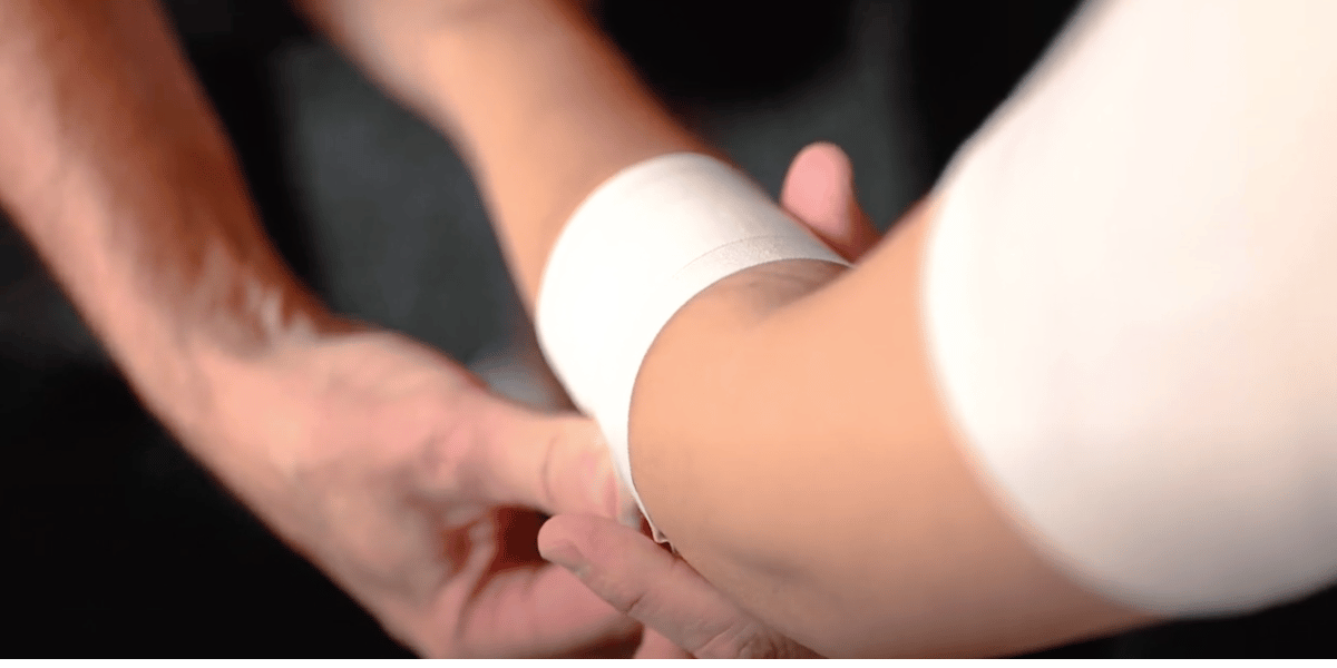 Physical therapist applying tape for Tennis Elbow